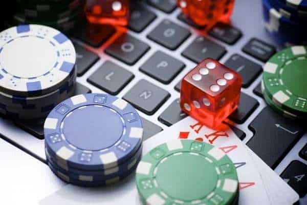 poker chips, dice, and cards on a laptop computer keyboard signifying online gambling